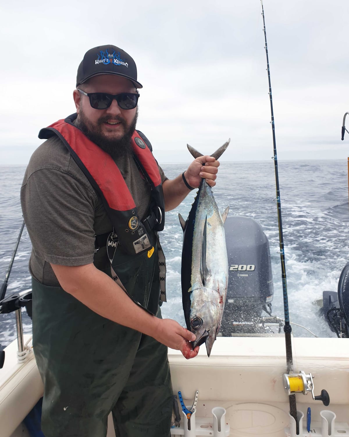 Jesse, owner of Coastwise IT, holding a freshly caught tuna on a fishing boat offshore
